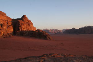 Röd sand och klippor i Wadi Rum i kvällsljus